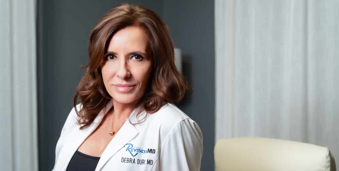 Dr. Debra Durst headshot in RevitalyzeMD scrubs